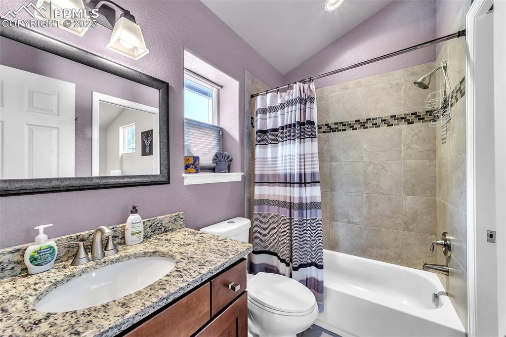 Image 35 of 49: Apartment: Bathroom featuring lofted ceiling, vanity, shower / tub combo, a