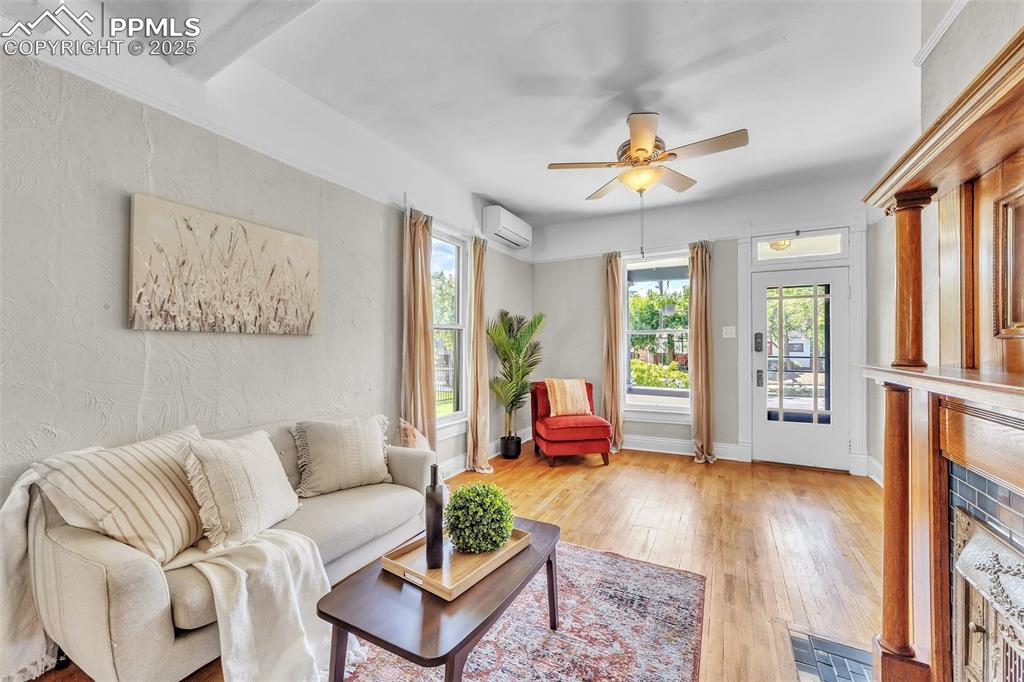 Image 5 of 49: Living room with a wall mounted air conditioner, light wood finished floors