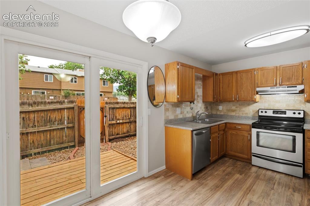 Image 10 of 30: Step from the kitchen and dining area to the newer wood deck in the enclose