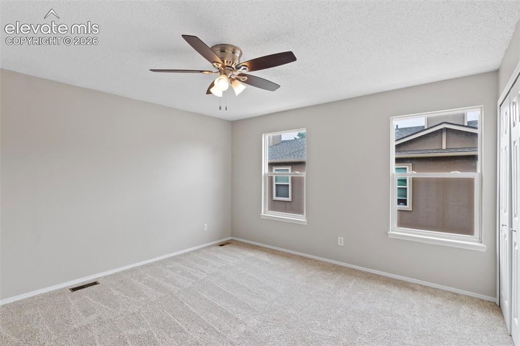 Image 18 of 30: The spacious primary bedroom features abundant natural light and a double c