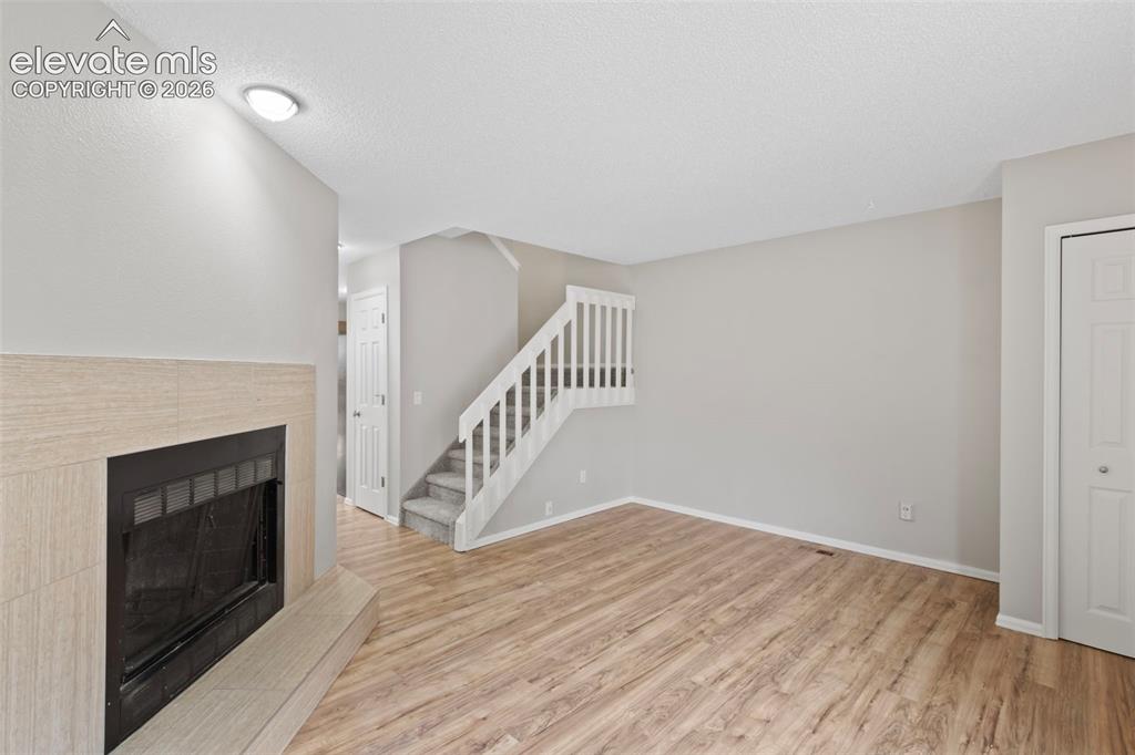 Image 5 of 30: A fresh coat of paint, LVP flooring, and a wood-burning fireplace beckon y