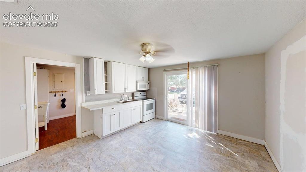 Image 10 of 23: Kitchen area featuring white cabinetry, a single basin sink, and a built-in