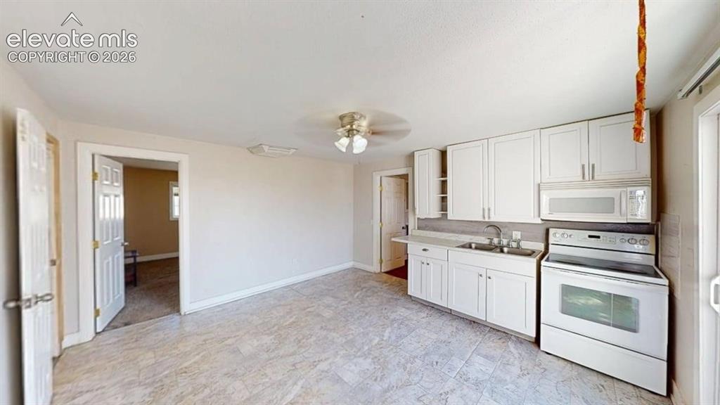 Image 11 of 23: White cabinetry, white appliances, light-toned flooring, and a ceiling fan