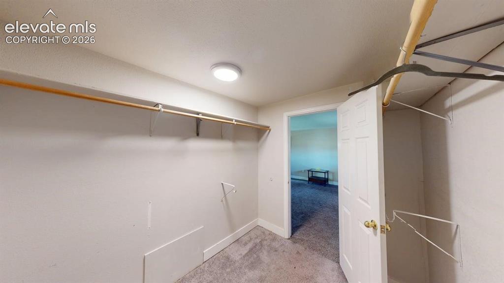 Image 16 of 23: Spacious walk-in closet featuring dual clothing rods with hanging space, ca