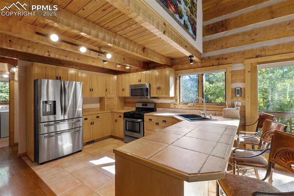 Image 13 of 46: Laundry is on the left. Kitchen window has view to the side yard and drivew