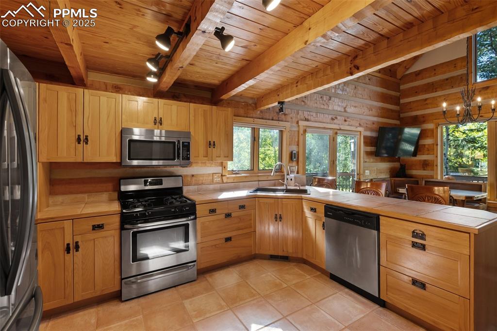 Image 15 of 46: Dining area under chandelier. Door gives you access to the deck and steps t