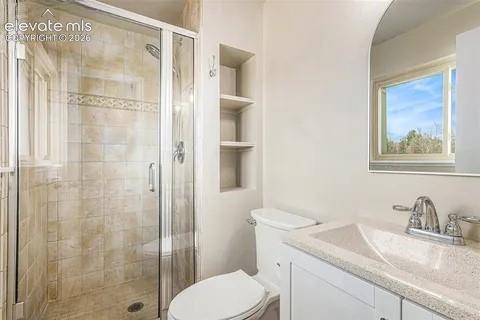 Image 11 of 26: Master Bathroom featuring a glass-enclosed shower with tiled walls and deco