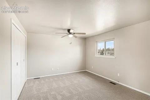 Image 14 of 26: 2nd upper bedroom Carpeted room featuring a single window, a ceiling fan wi