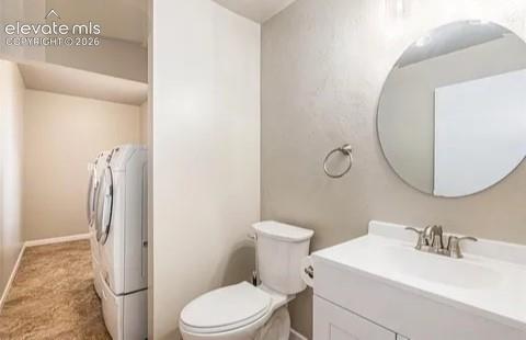 Image 21 of 26: lower bathroom and Compact laundry area featuring stacked appliances and a