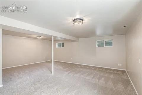 Image 22 of 26: Spacious room featuring light gray carpeting, neutral wall color, and two c