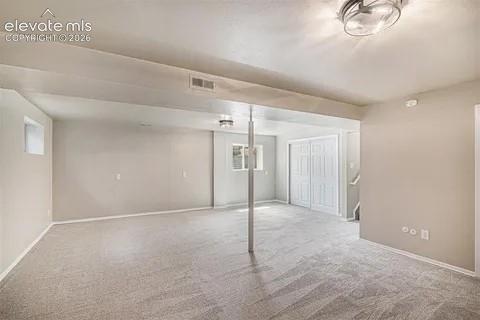 Image 24 of 26: Spacious room featuring light-toned carpet flooring, neutral painted walls,