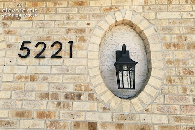 Image 3 of 26: Exterior brickwork featuring an oval stucco recess with a black lantern-sty