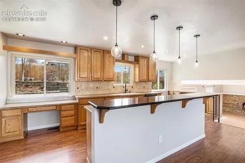 Image 8 of 26: Kitchen featuring natural wood cabinetry, a built-in desk area, a kitchen i