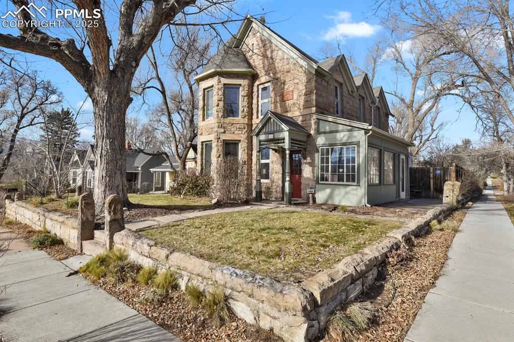 Caption: Historic home on a corner lot surround by an original stone wall. 