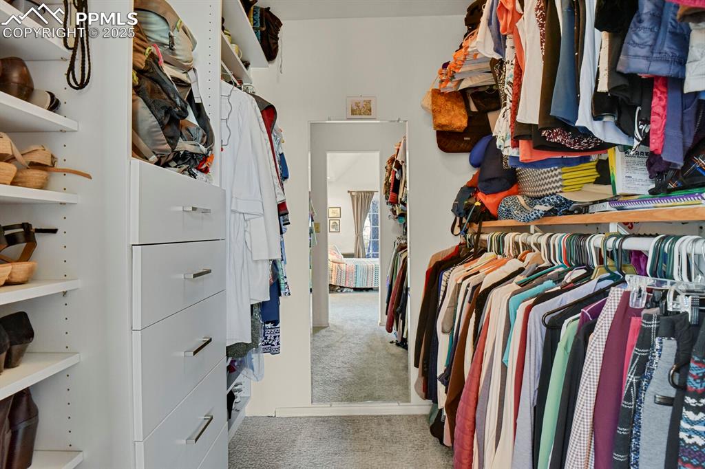 Image 17 of 34: Primary walk-in closet with custom built-ins