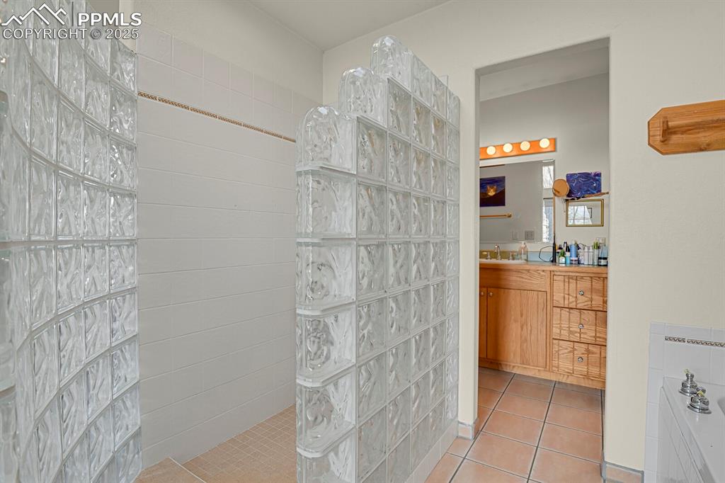 Image 18 of 34: Glass block walk-in shower in primary bathroom