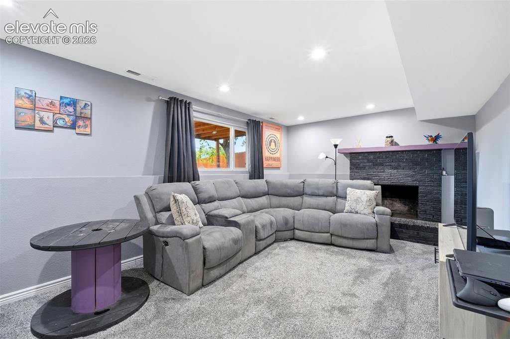 Image 19 of 46: Large Family Room w/ Wood Burning Fireplace and Garden Level Windows