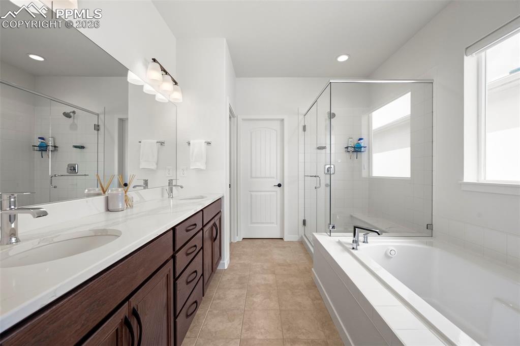 Image 21 of 37: Bathroom featuring a dual vanity with a white countertop and wood-finish ca