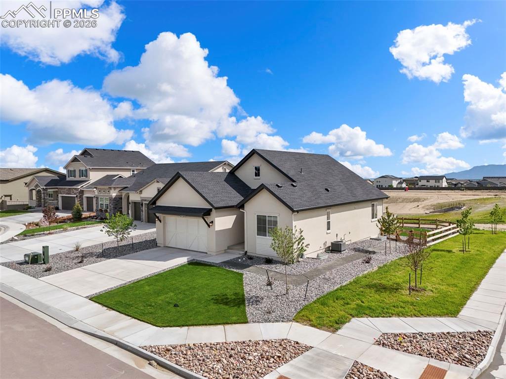 Image 31 of 37: Contemporary stucco exterior featuring an attached garage and dark shingle 