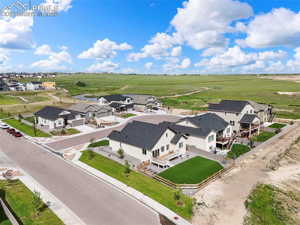 Image 36 of 37: Modern residential development featuring a paved road, sidewalks, and stree