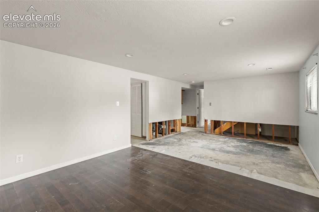 Image 18 of 24: Spacious interior featuring partial wood-finish flooring, recessed lighting