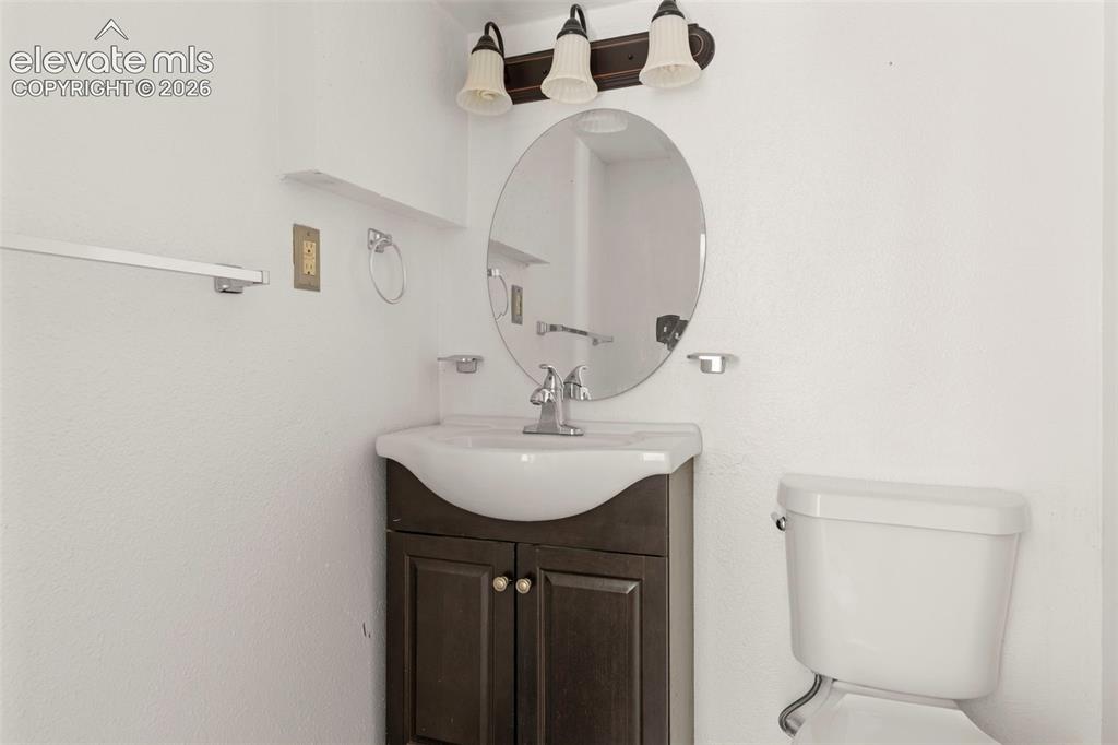 Image 19 of 24: Bathroom featuring a dark wood-finish vanity with an integrated white sink,