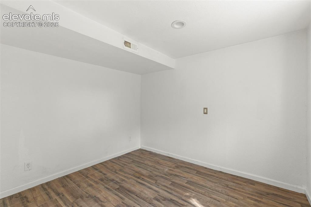 Image 20 of 24: Room featuring wood-finish flooring, white walls, recessed lighting, and wh
