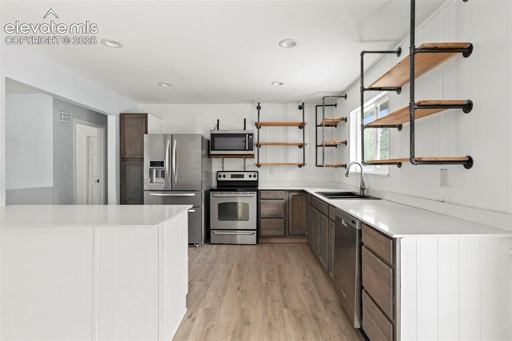 Image 8 of 24: Kitchen area with stainless steel appliances