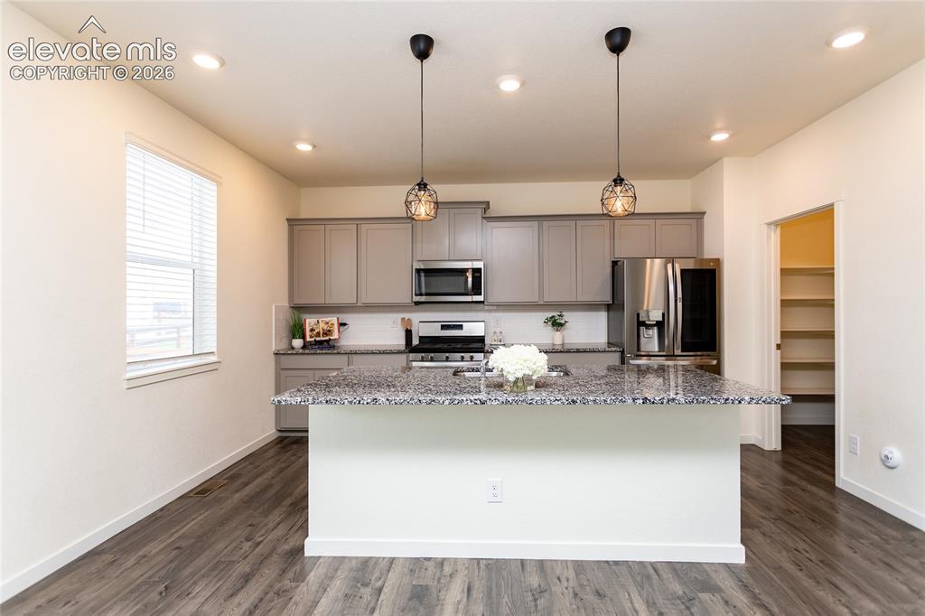 Image 12 of 48: Kitchen is highlighted by the large island offering countertop seating.