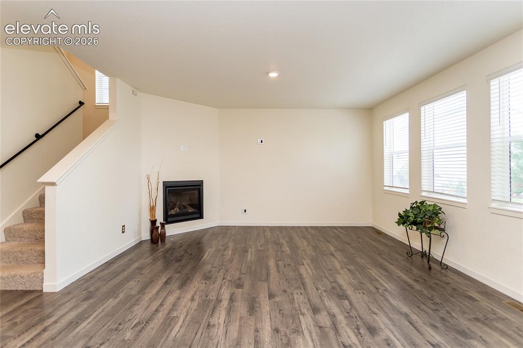 Image 8 of 48: Spacious living room is highlighted by a cozy fireplace.