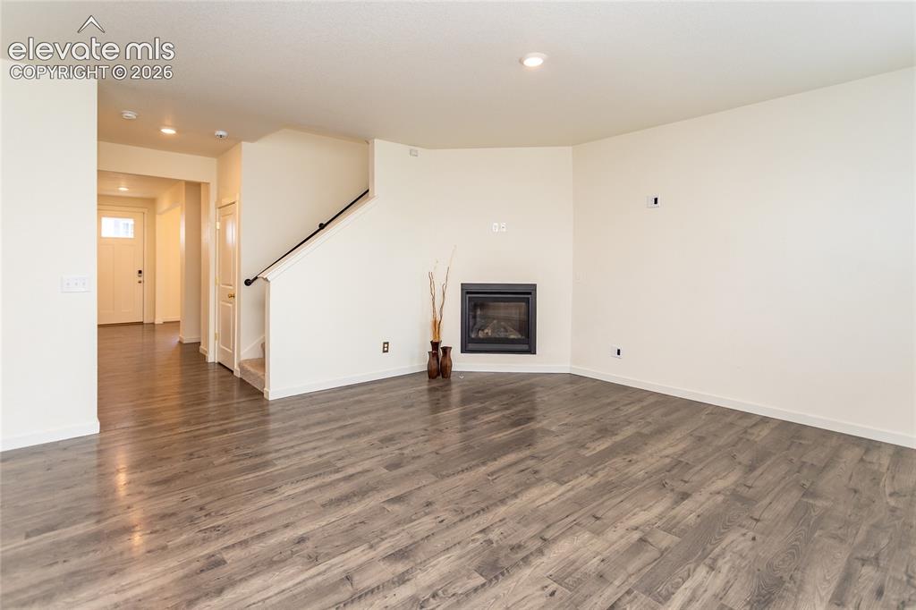 Image 9 of 48: Another view of the living room and the entry hallway.