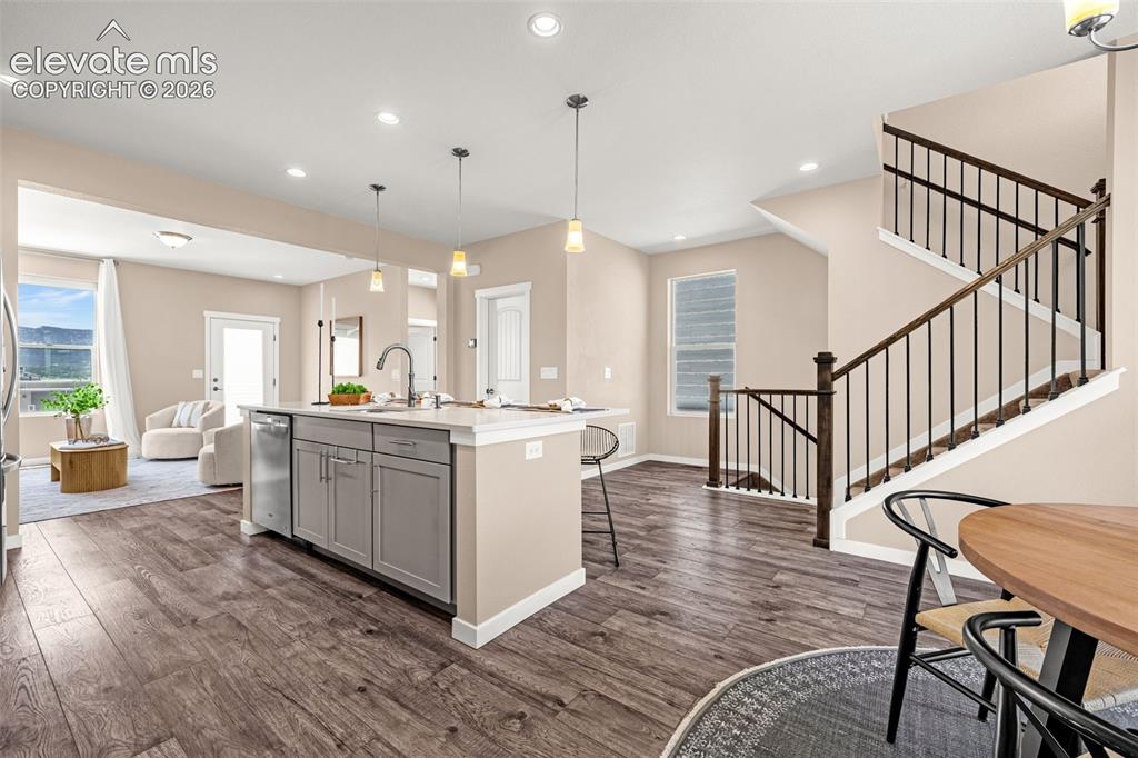Image 10 of 28: Open-concept living area with wood-finish flooring, a kitchen island featur