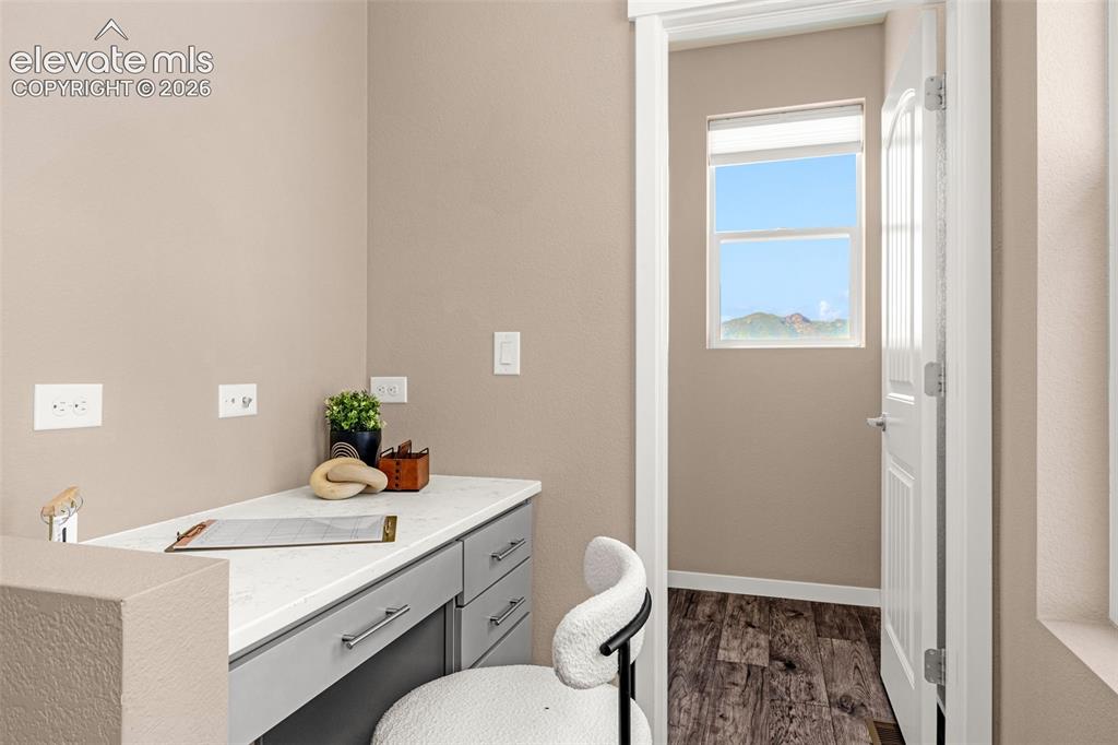 Image 15 of 28: Built-in desk with a light-toned countertop, integrated cabinetry, and wood
