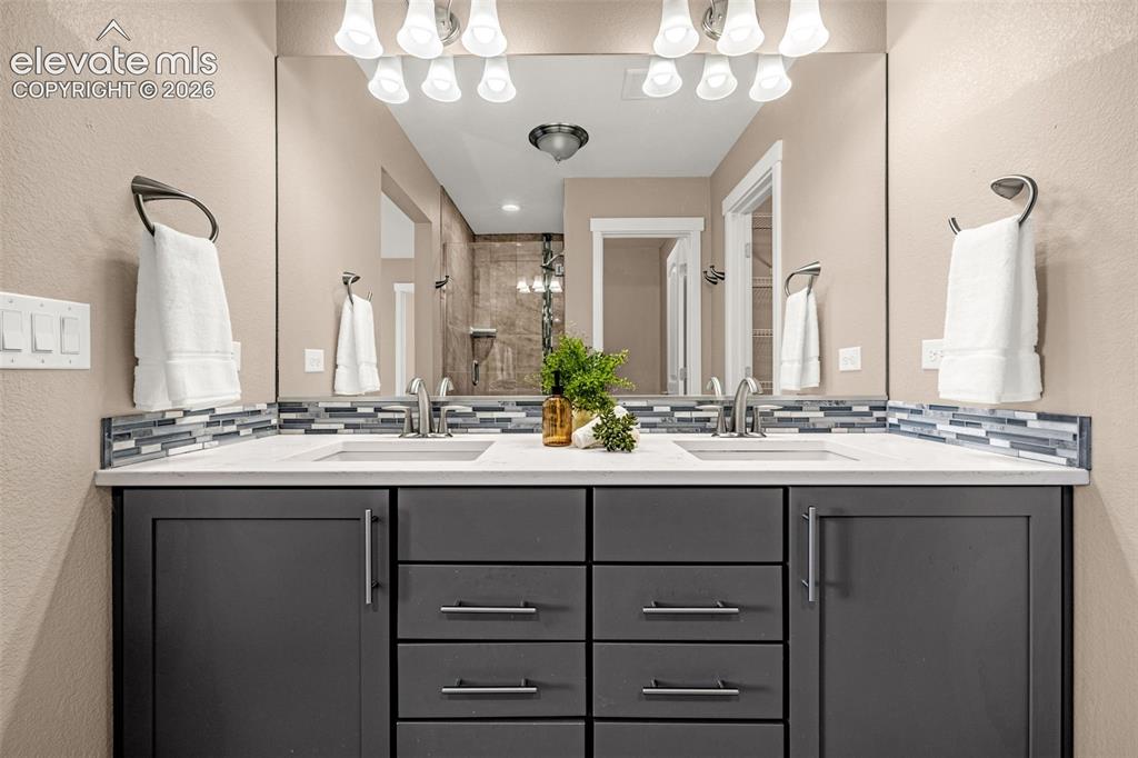 Image 18 of 28: Dual undermount sinks with chrome faucets, set into white countertops