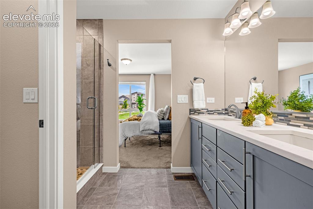 Image 19 of 28: Spacious bathroom featuring a dual vanity with light gray cabinetry, a full