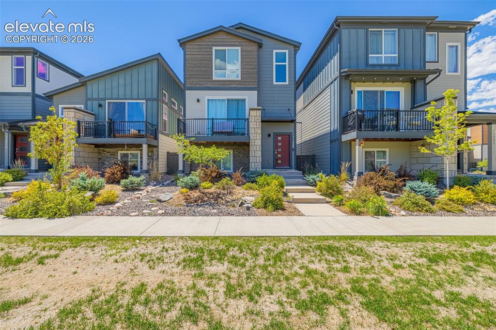 Image 28 of 32: Modern multi-story exterior with vertical and horizontal siding