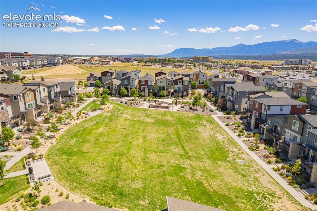 Image 32 of 32: Expansive community green space featuring a large lawn, integrated walkways