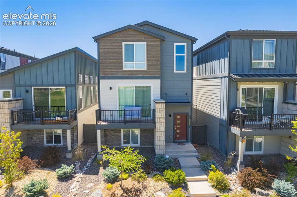 Image 5 of 28: Modern facade featuring mixed siding materials, a balcony with black railin