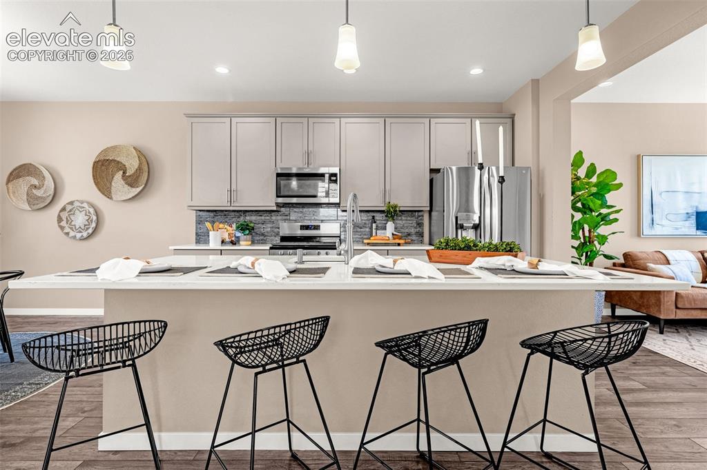 Image 6 of 28: Spacious kitchen island with seating, stainless steel appliances, grey shak