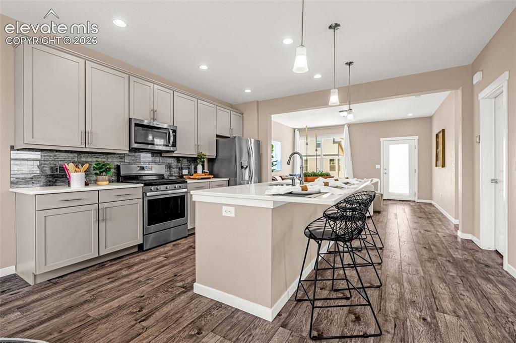 Image 7 of 28: Kitchen featuring recessed lighting, a kitchen island with pendant lights,