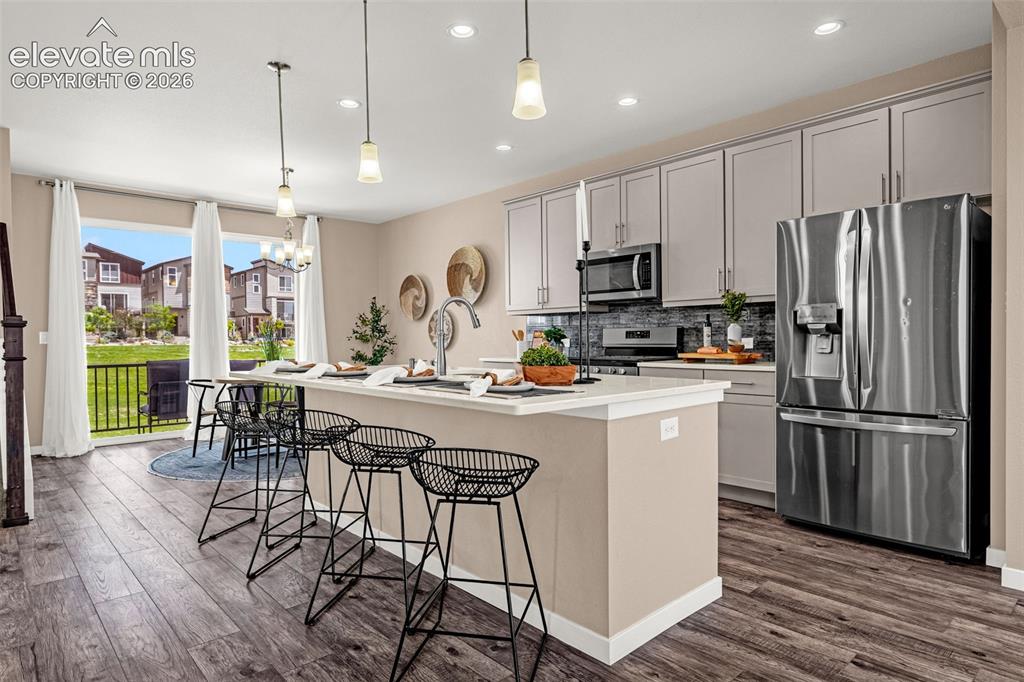 Image 8 of 28: Kitchen featuring a central island, wood-finish flooring, stainless steel a