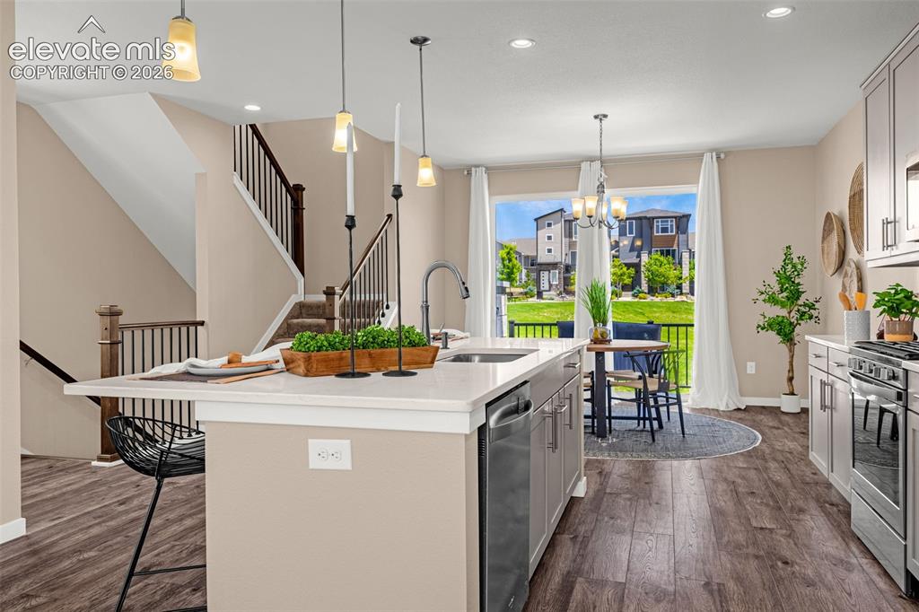 Image 9 of 28: Kitchen island with a light-toned countertop, stainless steel appliances, w