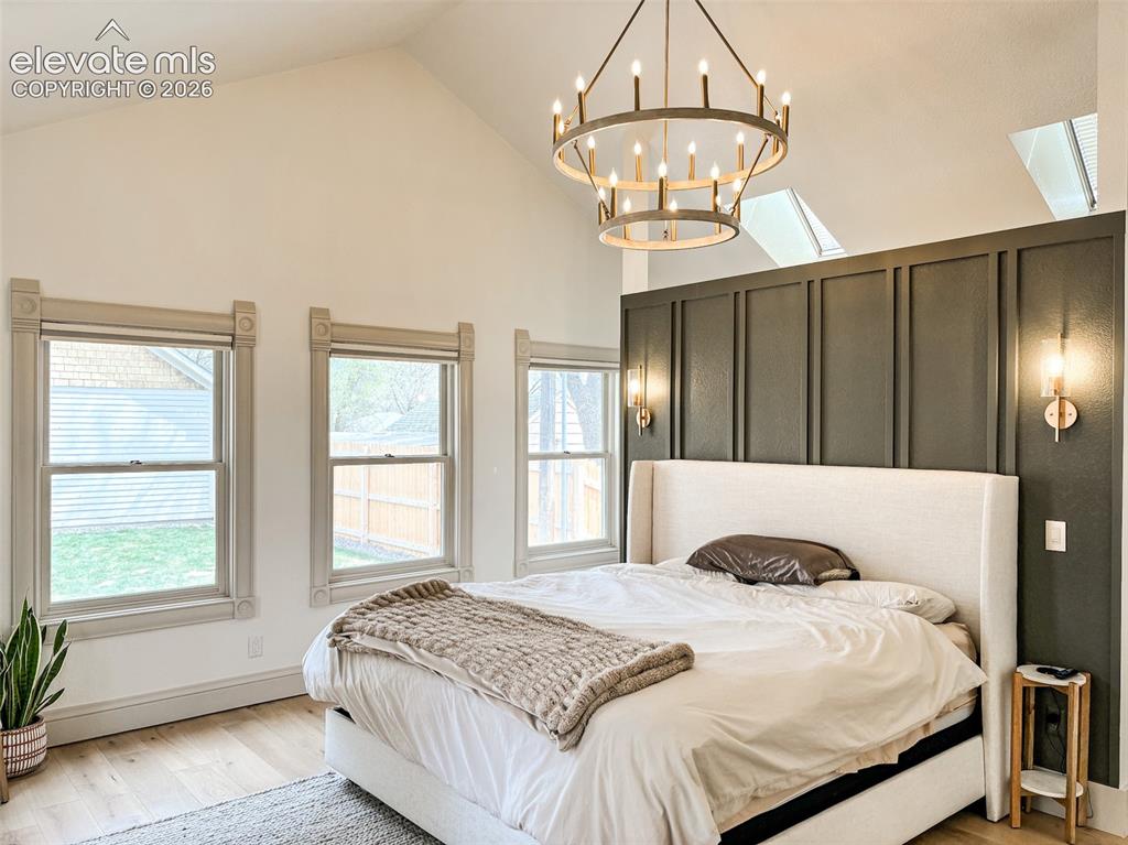 Image 10 of 33: Vaulted ceiling with an architectural chandelier and two skylights