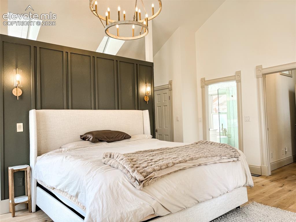 Image 11 of 33: Vaulted ceiling room featuring a decorative accent wall with sconce lightin