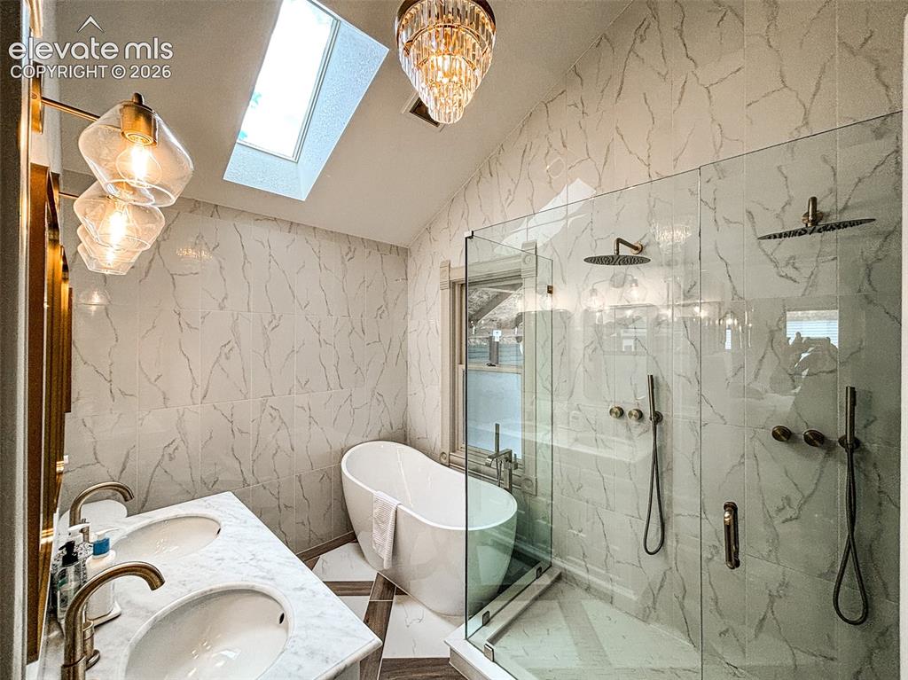 Image 14 of 33: Bathroom featuring a double vanity with undermount sinks, a freestanding so