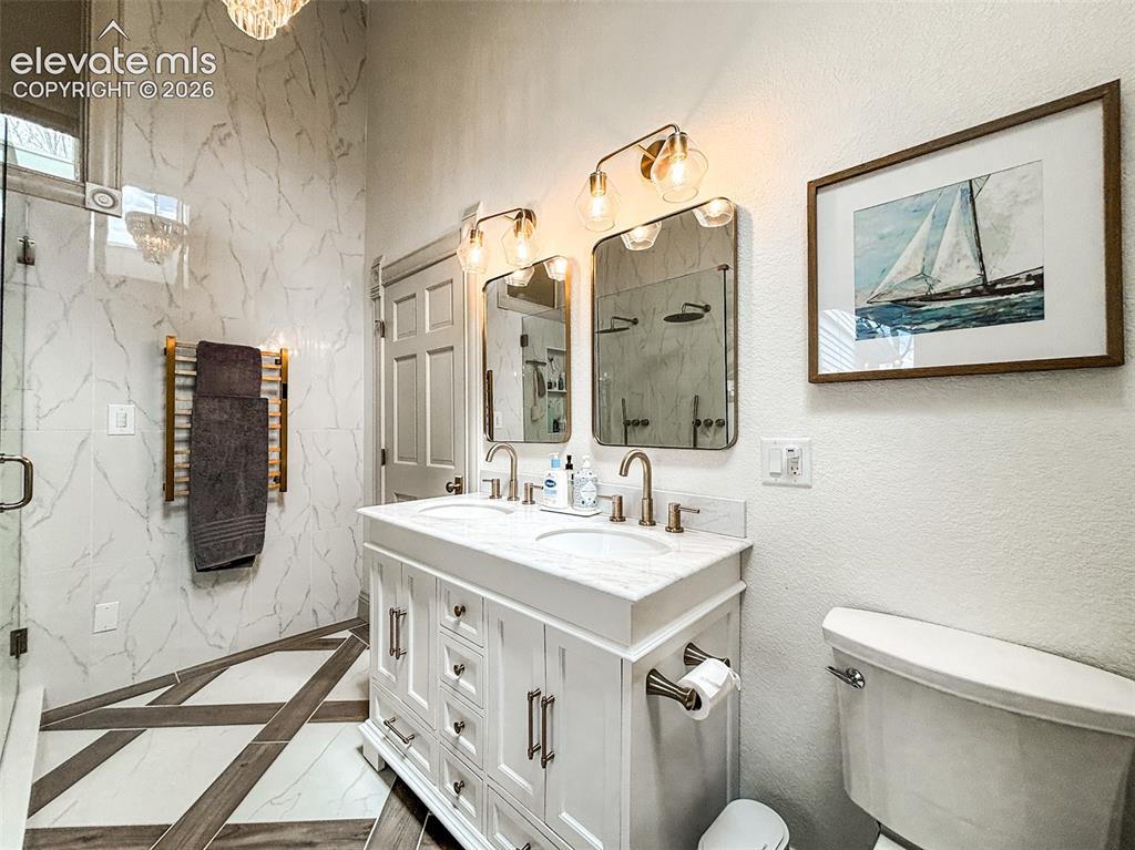 Image 15 of 33: Double vanity with white cabinetry and integrated sinks featuring brushed n