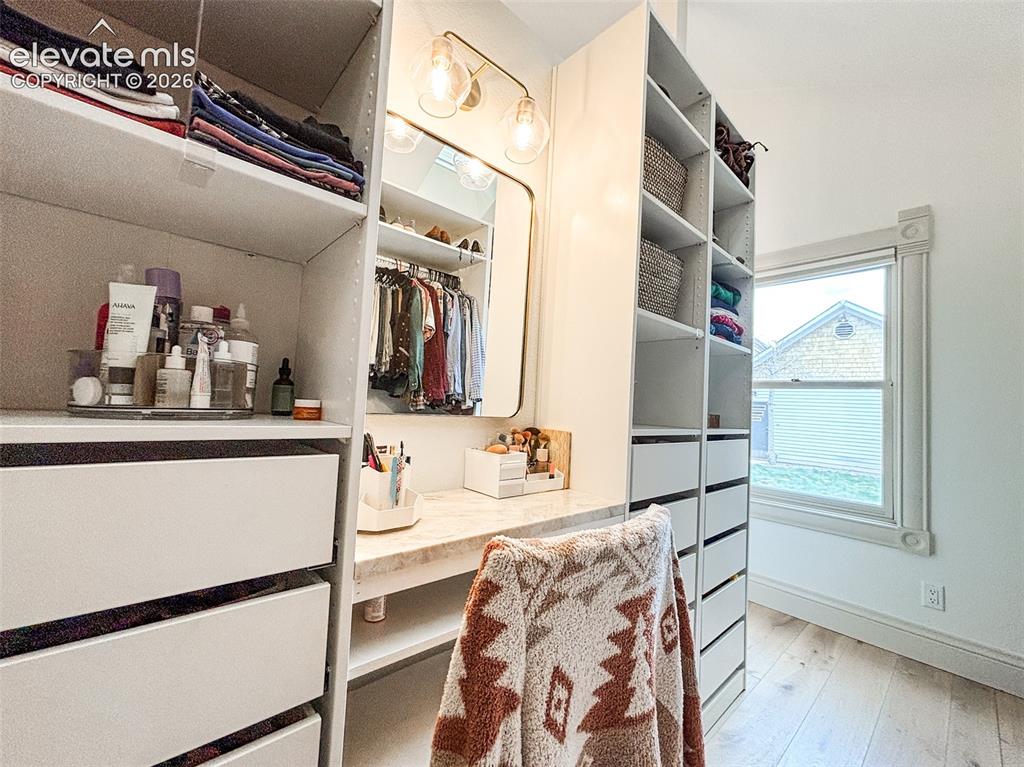 Image 18 of 33: Built-in custom closet system featuring white cabinetry, integrated shelvin