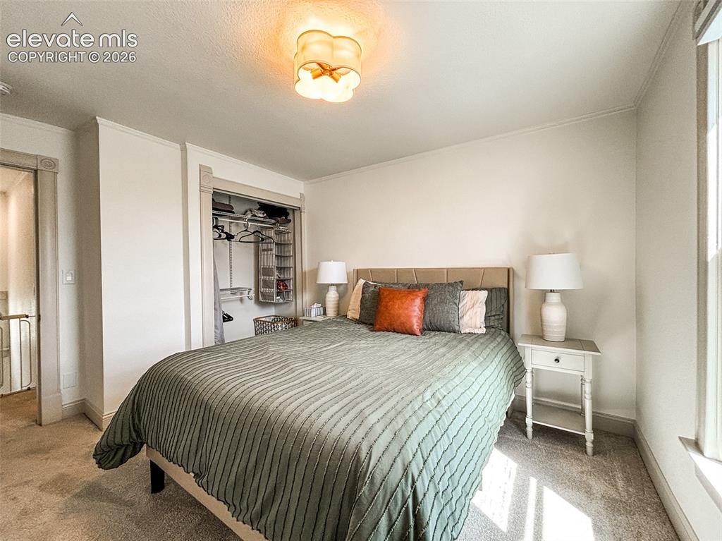 Image 24 of 33: Carpeted room featuring light-toned walls and trim, a window, and a built-i