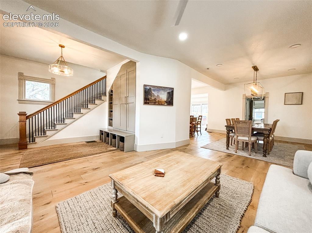 Image 3 of 33: Open-concept living area featuring wood-finish flooring, a contemporary sta