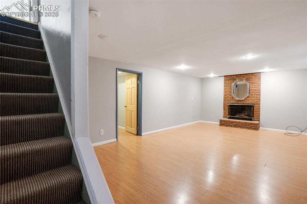 Image 17 of 35: Unfurnished living room featuring light wood-style flooring, stairway, and